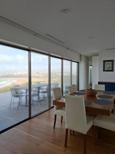 a dining room with a table and chairs and a balcony at Porto Sunset flat in Vila Nova de Gaia