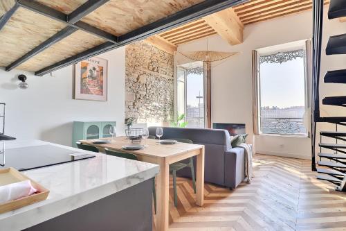 une cuisine et un salon avec une table et un canapé dans l'établissement Charming apartment with an unobstructed view, à Lyon
