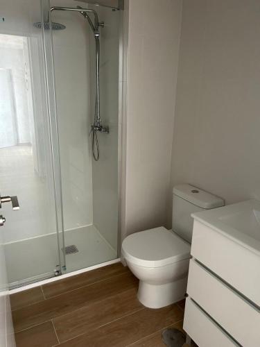 a white bathroom with a toilet and a shower at Life Apartments Arcos 27 in Jerez de la Frontera