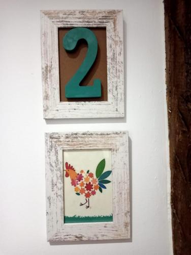 two framed pictures of a chicken on a wall at Las Gallinas de María in San Miguel de Aras