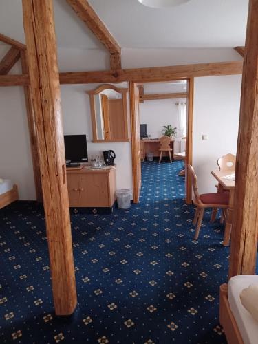 a hotel room with a desk and a room at Pension und Gaststätte "Zur Brauschänke" in Schöneck