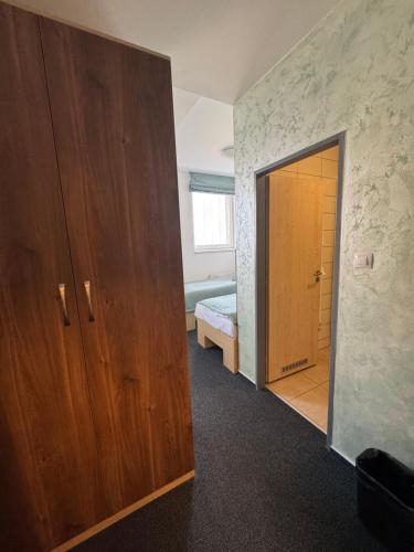a bedroom with a bed and a wooden door at Sport hotel Sletiště in Kladno