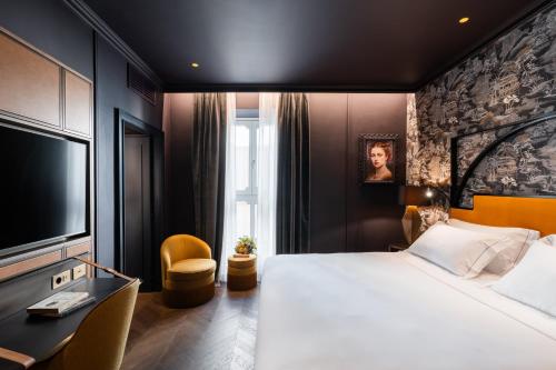 a hotel room with a large bed and a tv at The Goethe Hotel - Small Luxury Hotels of the World in Rome