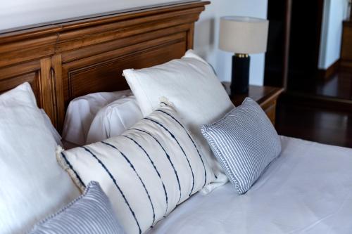 a bed with white pillows and a wooden headboard at Katrapona in Getaria