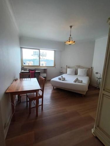 - une chambre avec un lit, une table, une table et des chaises dans l'établissement Appartement cozy avec garage Biarritz Plage, à Biarritz