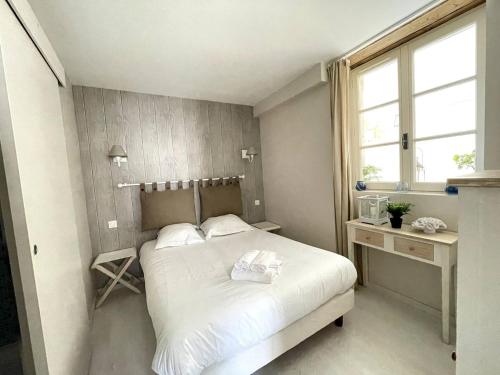 a small bedroom with a white bed and a window at Apt duplex ou plain pied tout confort plein centre ville Bayeux proche commerces, restaurants, avec terrasse privative ou jardin commun aménagé clos, parking gratuit à proximité, proche plages du débarquement in Bayeux