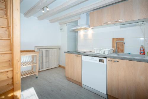 une cuisine avec des appareils électroménagers blancs et des armoires en bois dans l'établissement Chalet Koch, à Saint-Pierre-de-Chartreuse