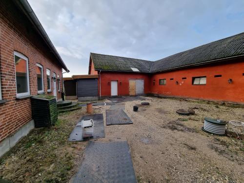 an empty yard in front of a brick building at Gæstehuset på Agerholm in Helsinge