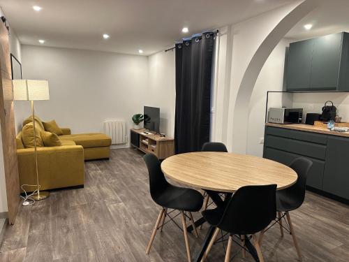 un salon avec une table et des chaises et une cuisine dans l'établissement Gîte Le Tilleul, à Aspremont