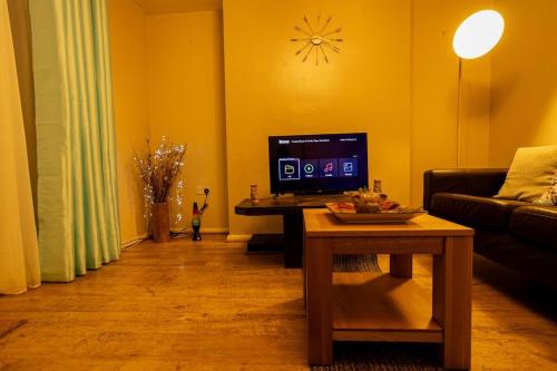 Μια τηλεόραση ή/και κέντρο ψυχαγωγίας στο Charming and Cosy Home- Sleeps 4, Free Parking, Private Patio - Steps from Warwick Castle & Town! Perfect for Workstations, Races and Cotswolds Getaways! Book Now