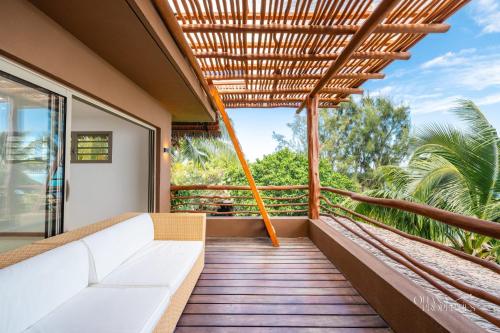 a balcony of a house with a white couch at Villa Iti - 3BR Oceanfront Villa w Beautiful Pool in Maharepa