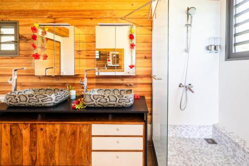 a bathroom with two sinks and a mirror at Villa Iti - 3BR Oceanfront Villa w Beautiful Pool in Maharepa