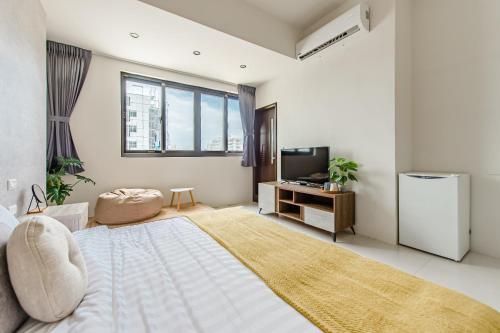 a bedroom with a large bed and a television at Penghu SunSea Hall in Magong