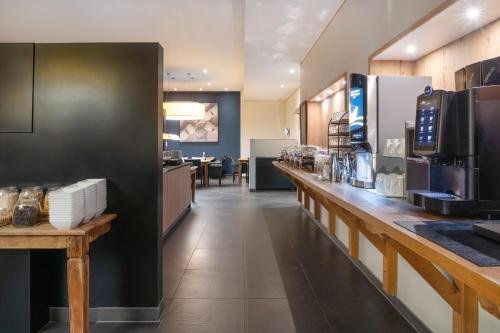 a restaurant with a long counter with a coffee shop at Hotel Wolfsburg Centrum, Affiliated by Meliá in Wolfsburg