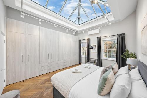 a bedroom with a large bed and a skylight at The Chelsea Villa in London