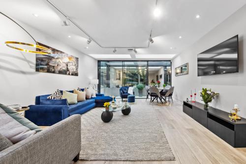 a living room with blue couches and a table at The Chelsea Villa in London