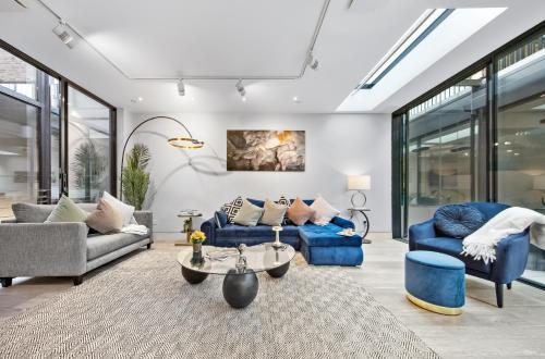 a living room with two blue couches and a table at The Chelsea Villa in London