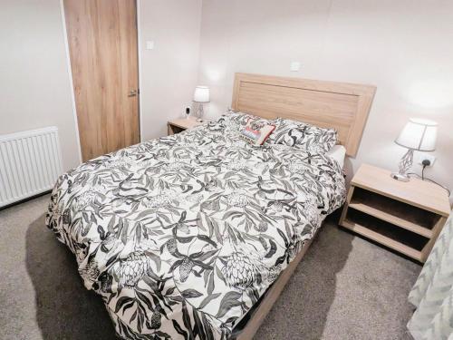 a bedroom with a bed with a black and white comforter at Mollys Lodge in Ryde