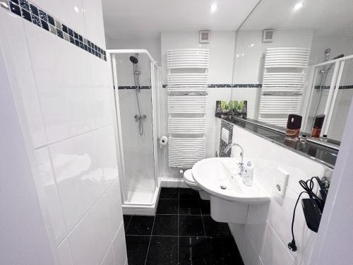 a white bathroom with a shower and a sink at VAZ Apartments Freiheit 1 für Monteure und Fachkräfte, Küche, Balkon, TV, WLAN, Parkplatz, Autobahnähe in Remscheid