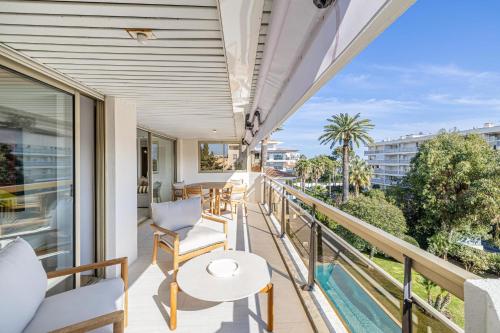 d'un balcon avec une table, des chaises et une piscine. dans l'établissement REF 1980 - Cannes palm Beach sea view, à Cannes