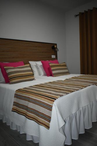 a bedroom with a large bed with colorful pillows at Casa da Vila in Campo Maior