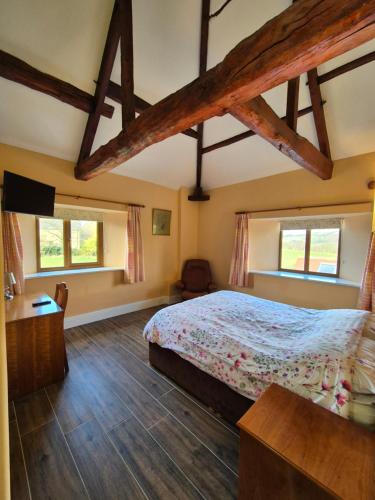 Un dormitorio con una cama y dos ventanas. en Padley Farm, en Bradfield
