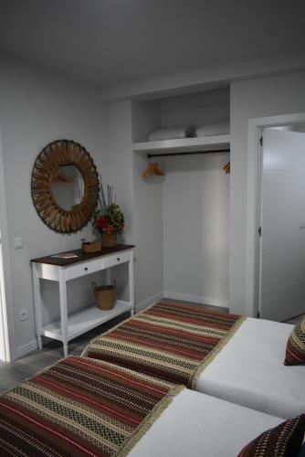a room with a bed and a mirror and a table at Casa da Vila in Campo Maior