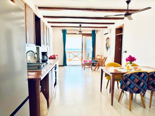 a kitchen with a table and a dining room at Just Heaven Apartments in Matemwe