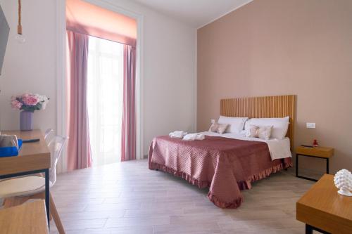 a bedroom with a bed and a desk and a window at Maison do re umberto in Naples