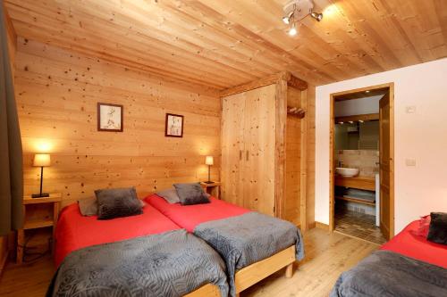 une chambre avec deux lits dans une cabane en rondins dans l'établissement la levanna, à Les Deux Alpes