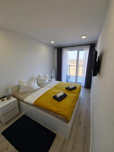 a bedroom with a large bed with a yellow blanket at Przytulny Apartament 406 IV piętro in Kołobrzeg