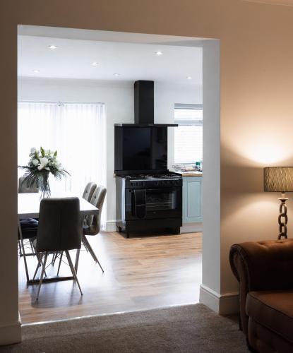 a living room with a dining room table and a kitchen at Large 4 Bed Home - Fast Wifi, Smart TV's & Free Parking - Near A66 in Stockton-on-Tees