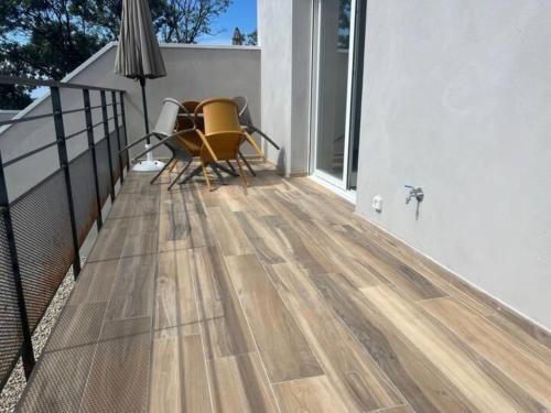 a balcony with a wooden floor and chairs on it at E casette in Oletta