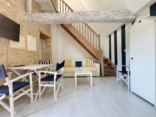 a living room with a couch and a table and chairs at Apt duplex ou plain pied tout confort plein centre ville Bayeux proche commerces, restaurants, avec terrasse privative ou jardin commun aménagé clos, parking gratuit à proximité, proche plages du débarquement in Bayeux