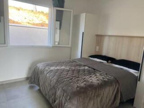 a bedroom with a bed and a window at E casette in Oletta