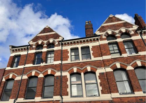 a large brick building with windows on top of it at Spacious Birmingham City Apartment in Birmingham