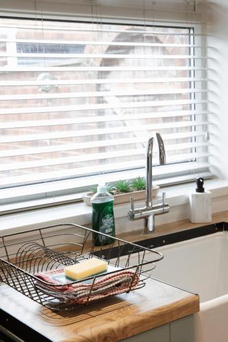a kitchen counter with a dish rack and a sink at Large 4 Bed Home - Fast Wifi, Smart TV's & Free Parking - Near A66 in Stockton-on-Tees