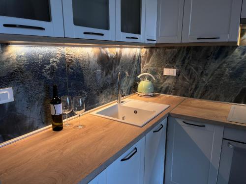 a kitchen counter with a sink and a bottle of wine at Apartment Nona Celina in Zadar