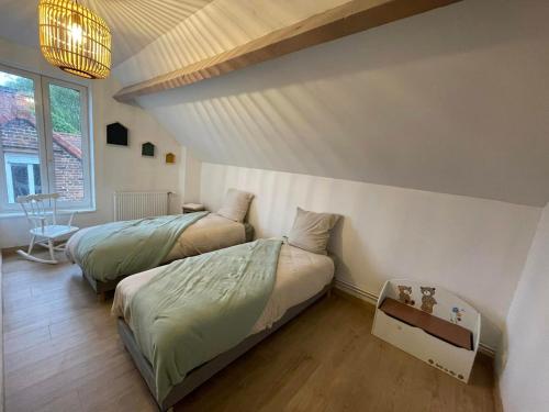 a bedroom with two beds and a window at Les HIRONDELLES CHAMBRES HOTES 10 PERSONNES in Festubert