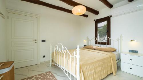 a bedroom with a white bed and a window at Villa Greta in Bodrum City