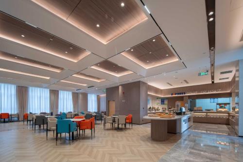 a lobby with a restaurant with tables and chairs at Holiday Inn Express Turpan, an IHG Hotel in Turfan