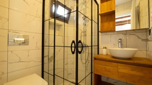 a bathroom with a sink and a glass shower door at Villa Greta in Bodrum City