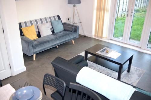 a living room with a couch and a table at Modern house in City Centre with private parking and gated property in Birmingham