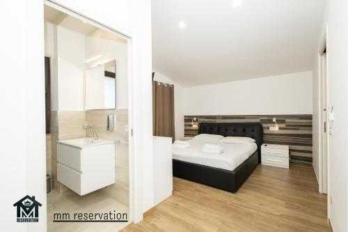 a bedroom with a bed and a sink and a mirror at Le Querce Appartamento Roma in Infernetto