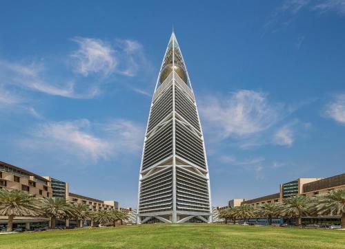 a tall building with palm trees in front of it at Mandarin Oriental Al Faisaliah, Riyadh in Riyadh