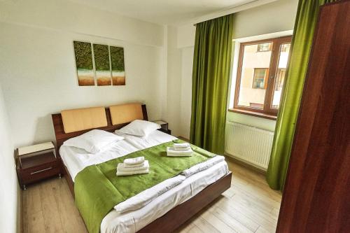 a bedroom with a bed with two towels on it at Miraj Apartaments - Exclusive Residence in Mamaia