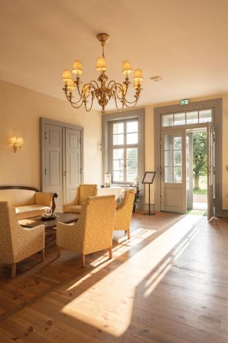 a living room with a chandelier and a table and chairs at Peter's Resort in Redefin