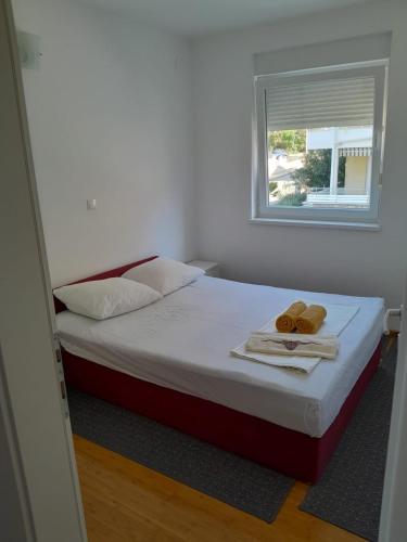 a bedroom with a bed with two towels and a window at Apartman Novalja - Put Lokvice in Novalja