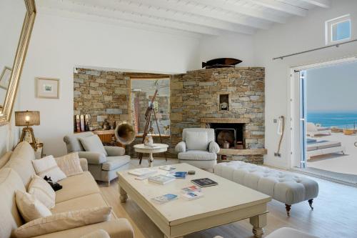 a living room with a couch and a fireplace at Blueros - Olive suite in Megas Yialos-Nites