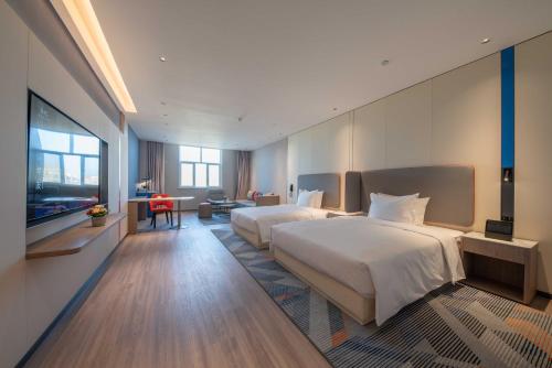 a hotel room with two beds and a television at Holiday Inn Express Turpan, an IHG Hotel in Turfan